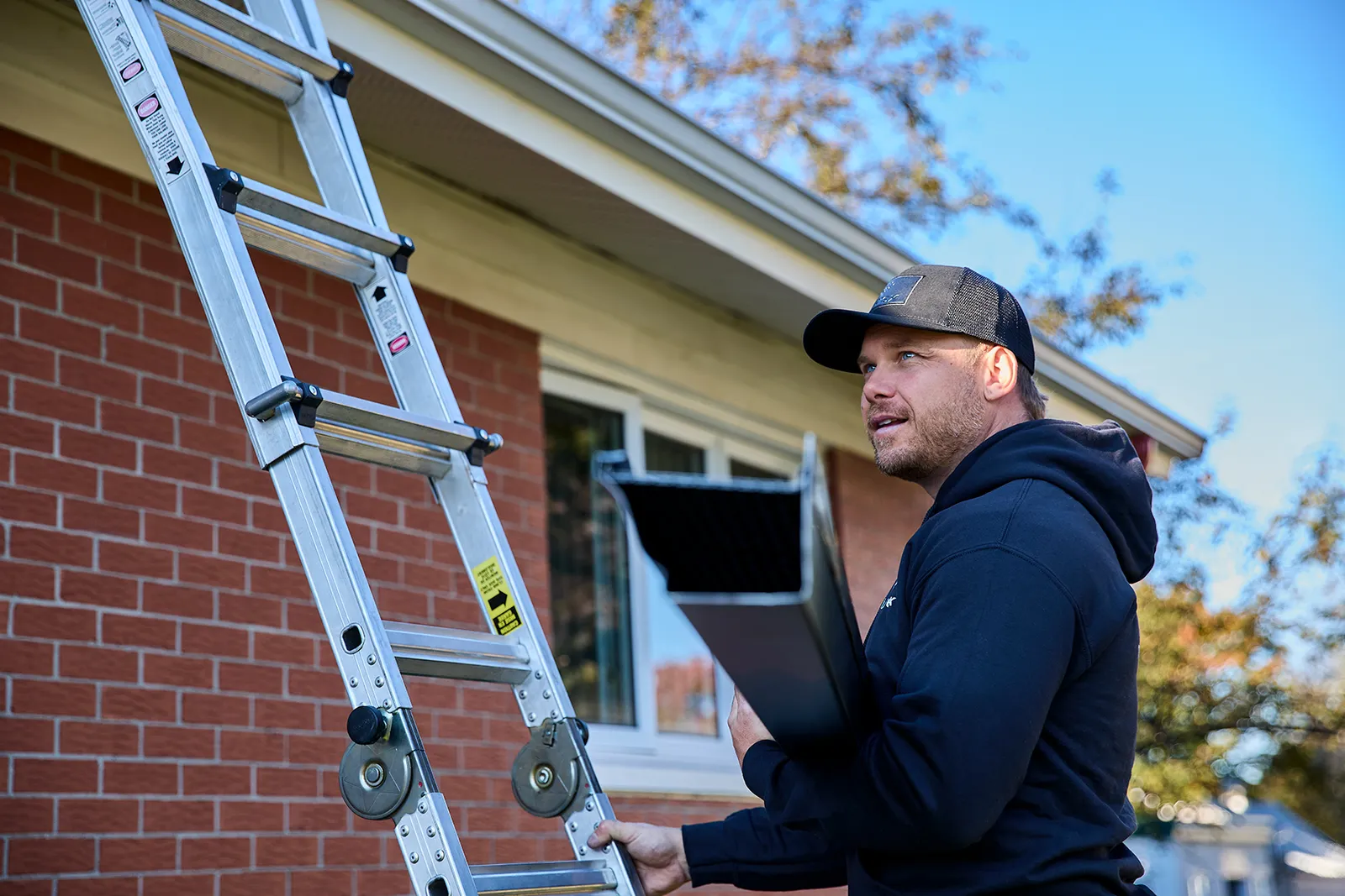 Crew installing eavestroughs at the roofline — Doug's Exteriors LTD, Edmonton & Alberta